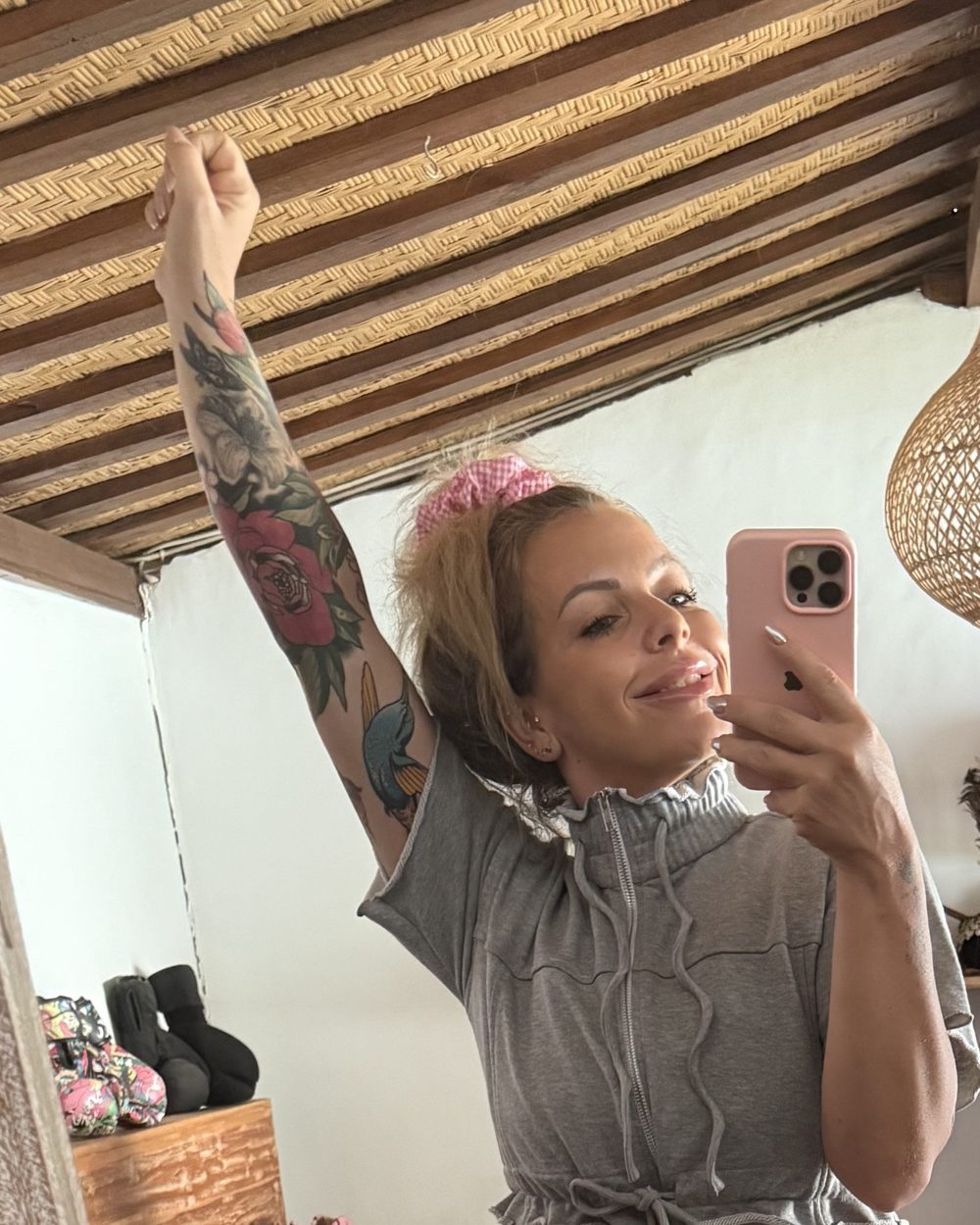 Dilara Maria Veh macht ein Spiegel-Selfie und streckt lachend einen Arm in die Luft.